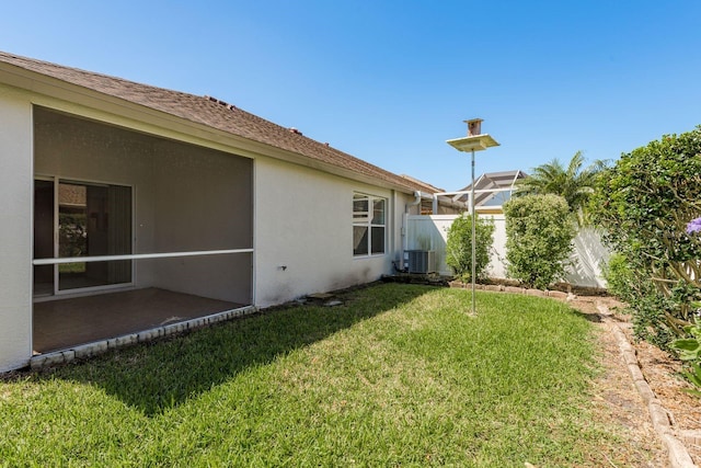 view of yard with fence and central AC