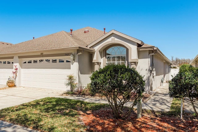 view of front of property featuring stucco siding, driveway, a garage, and roof with shingles