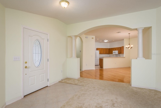 foyer entrance with baseboards, arched walkways, and light carpet