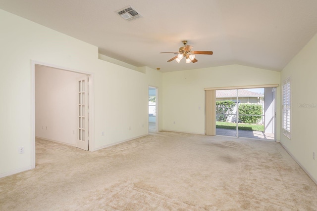 empty room featuring visible vents, a ceiling fan, carpet, and vaulted ceiling
