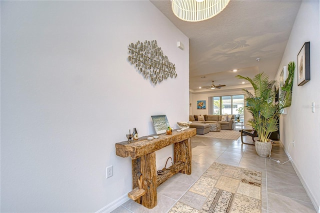 hallway with light tile patterned floors and an inviting chandelier