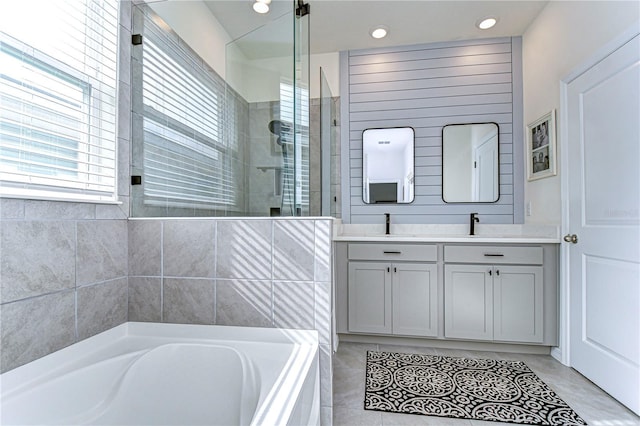 bathroom with tile patterned floors, vanity, and plus walk in shower