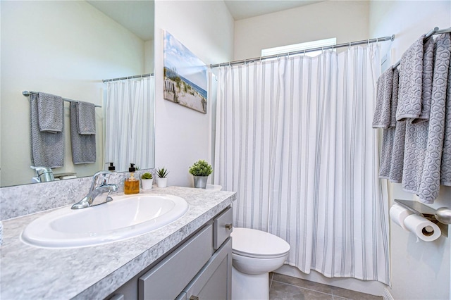 bathroom with tile patterned flooring, vanity, toilet, and walk in shower