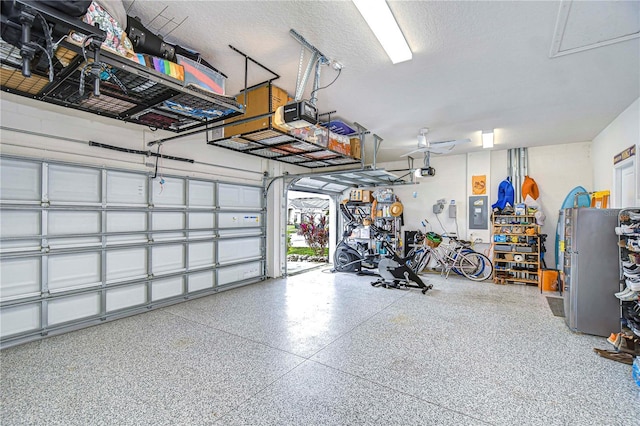 garage with electric panel and a garage door opener