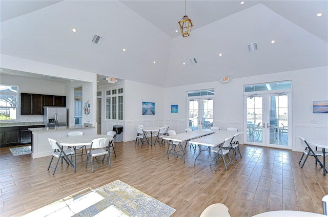 dining space with french doors, high vaulted ceiling, and a healthy amount of sunlight