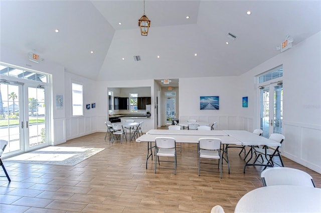 dining area with high vaulted ceiling and french doors