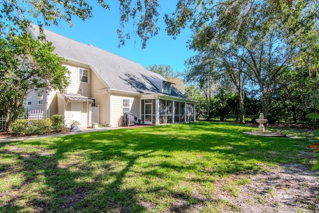 rear view of house with a yard and a sunroom