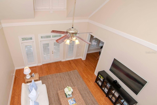 unfurnished living room featuring french doors, ceiling fan, crown molding, light hardwood / wood-style flooring, and lofted ceiling