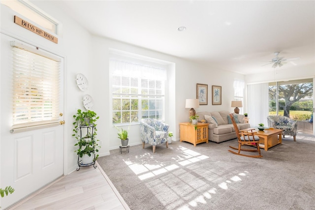 living room with light hardwood / wood-style flooring, a wealth of natural light, and ceiling fan