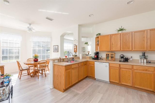 kitchen featuring ceiling fan, dishwasher, sink, kitchen peninsula, and light hardwood / wood-style floors