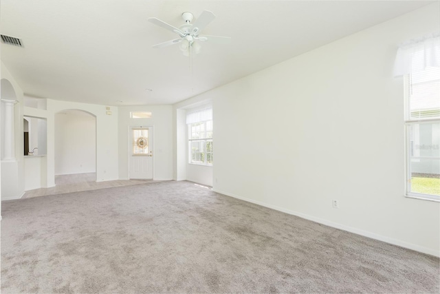 5733 Heronpark Pl, Lithia, FL 33547 - carpeted spare room with arched walkways, a ceiling fan, and healthy amount of natural light