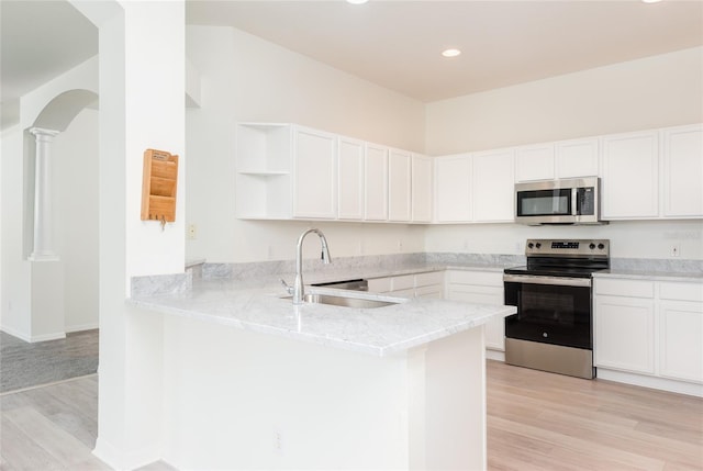 5733 Heronpark Pl, Lithia, FL 33547 - kitchen with appliances with stainless steel finishes, open shelves, a peninsula, light stone countertops, and light wood-type flooring