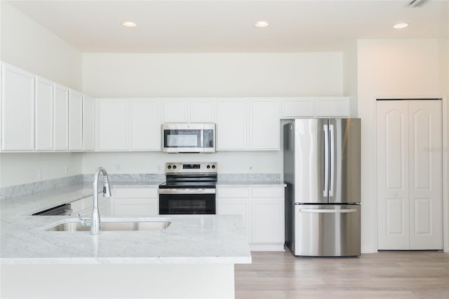 5733 Heronpark Pl, Lithia, FL 33547 - kitchen featuring stainless steel appliances, white cabinets, light stone counters, a peninsula, and recessed lighting