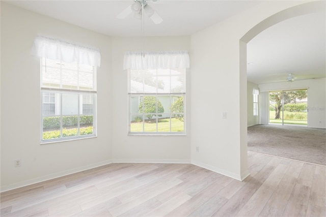 5733 Heronpark Pl, Lithia, FL 33547 - unfurnished room featuring ceiling fan, arched walkways, and light wood-type flooring