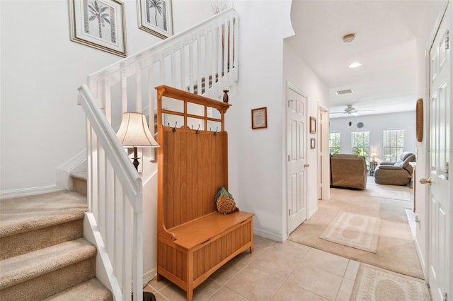 stairway with tile patterned floors and ceiling fan