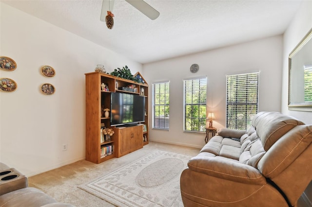 living room with light carpet, ceiling fan, and a textured ceiling