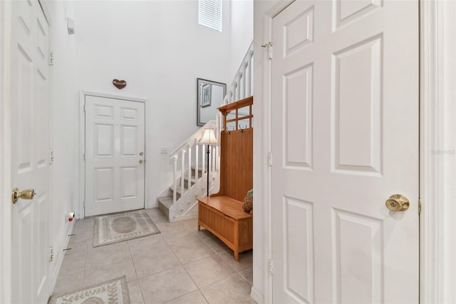 tiled foyer entrance featuring a towering ceiling