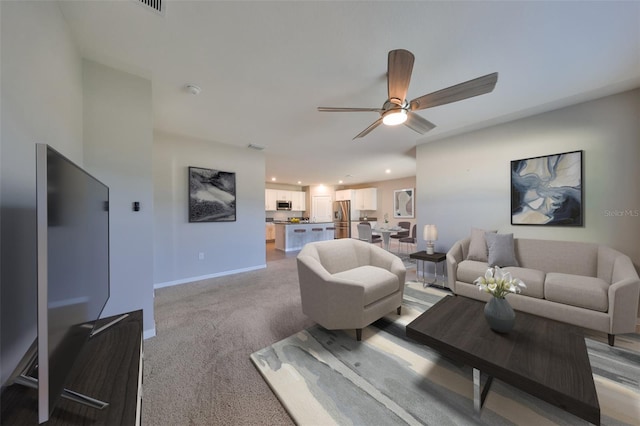 carpeted living room featuring ceiling fan