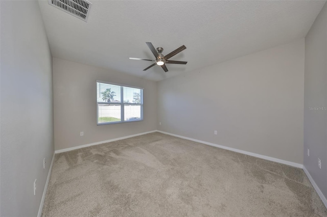 carpeted empty room featuring ceiling fan and a textured ceiling