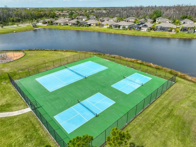 view of property's community featuring a yard, a water view, and tennis court