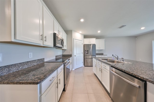 kitchen with white cabinets, light tile patterned floors, sink, and appliances with stainless steel finishes