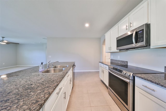 kitchen with white cabinetry, ceiling fan, dark stone counters, light tile patterned floors, and appliances with stainless steel finishes