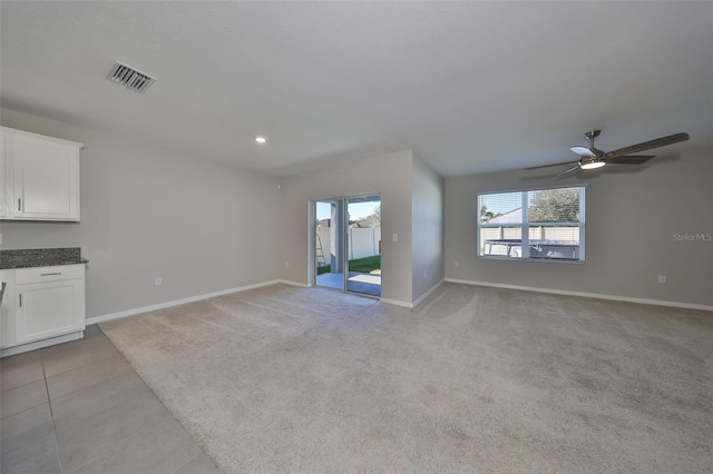 unfurnished living room featuring ceiling fan and light carpet