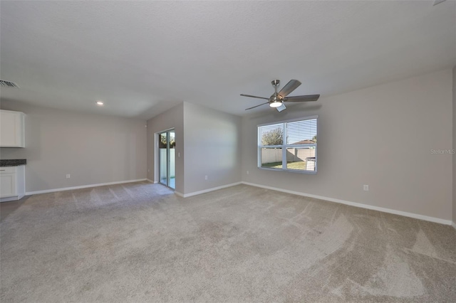 unfurnished living room featuring ceiling fan and light colored carpet