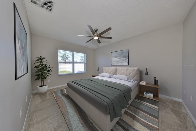 bedroom with ceiling fan, carpet floors, and a textured ceiling