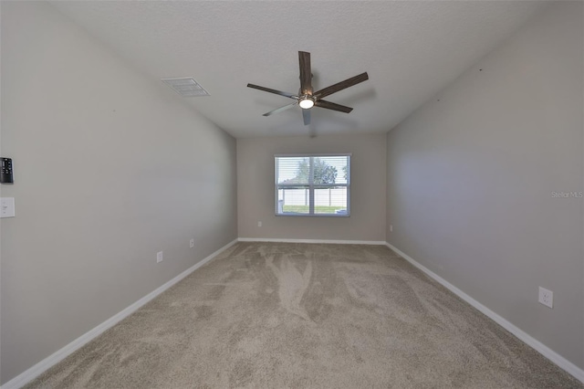 empty room with a textured ceiling, ceiling fan, and light carpet