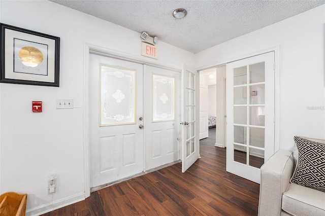 entrance foyer with dark hardwood / wood-style floors, a textured ceiling, and french doors