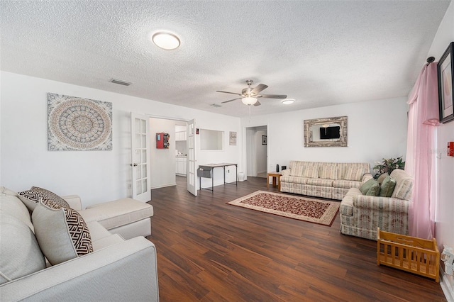 living room featuring ceiling fan, dark hardwood / wood-style flooring, a textured ceiling, and french doors