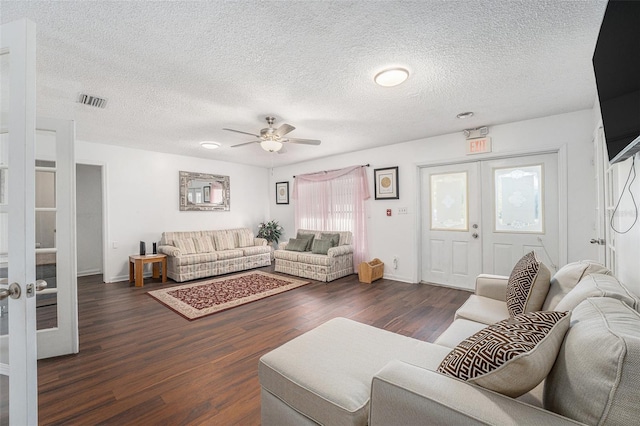 living room featuring a textured ceiling, ceiling fan, french doors, and dark hardwood / wood-style floors