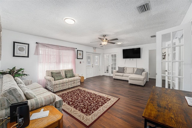 living room featuring french doors, dark hardwood / wood-style flooring, a textured ceiling, and ceiling fan