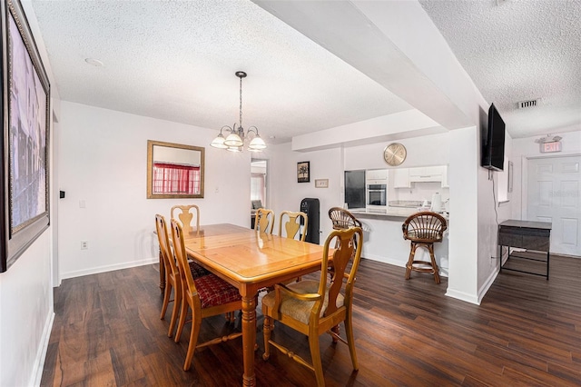 dining room with a textured ceiling, an inviting chandelier, and dark wood-type flooring