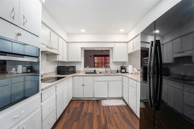 kitchen featuring white cabinets, dark wood-type flooring, black appliances, and sink