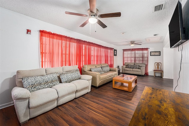 living room featuring dark wood-type flooring and a textured ceiling