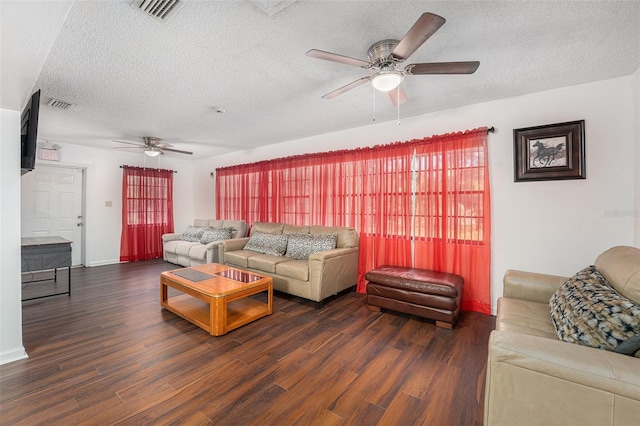 living room featuring dark wood-type flooring and a textured ceiling