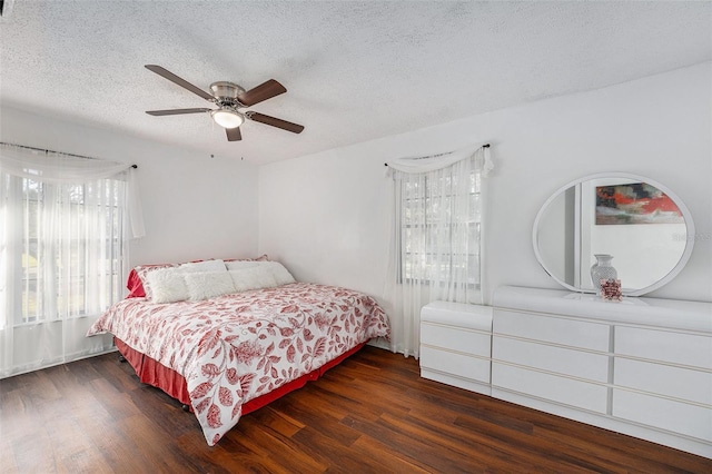 bedroom with ceiling fan, dark hardwood / wood-style flooring, and a textured ceiling