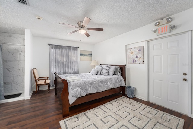 bedroom with a textured ceiling, ceiling fan, and dark wood-type flooring