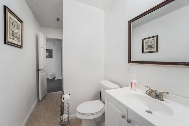 bathroom featuring toilet, vanity, a textured ceiling, and hardwood / wood-style flooring