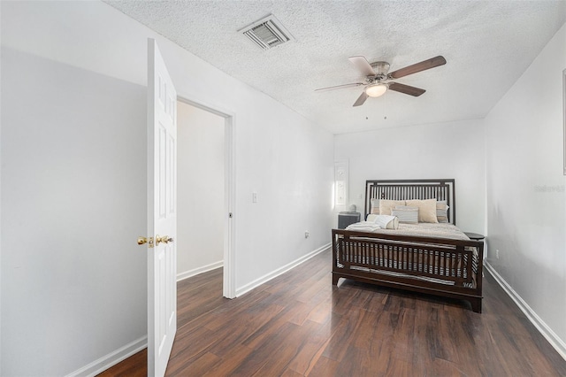 bedroom with ceiling fan, dark hardwood / wood-style floors, and a textured ceiling