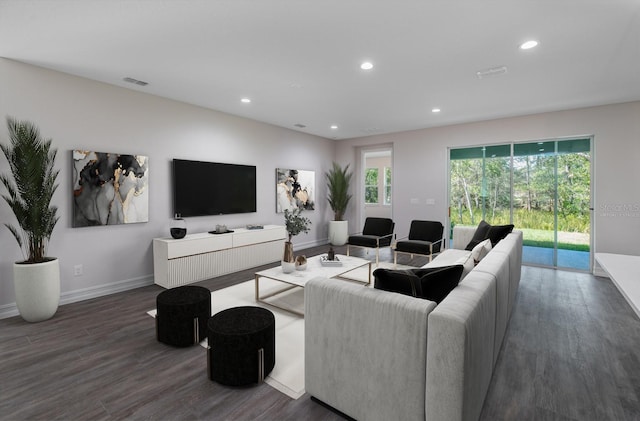 living room with dark wood-type flooring and a healthy amount of sunlight