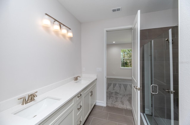 bathroom with tile patterned flooring, vanity, and walk in shower