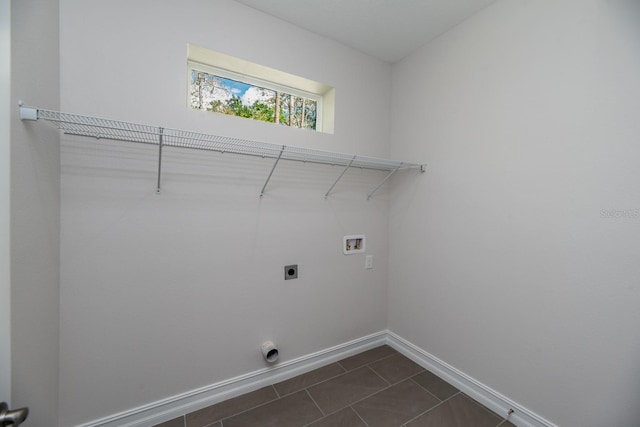 clothes washing area featuring hookup for an electric dryer, hookup for a washing machine, and dark tile patterned flooring