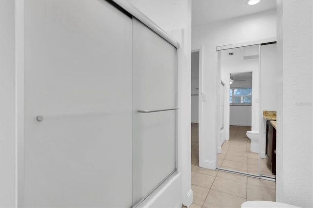 bathroom with tile patterned flooring, vanity, ceiling fan, and toilet