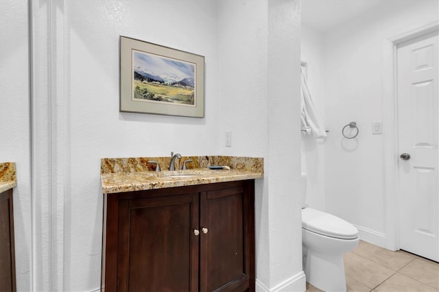 bathroom with toilet, vanity, and tile patterned floors