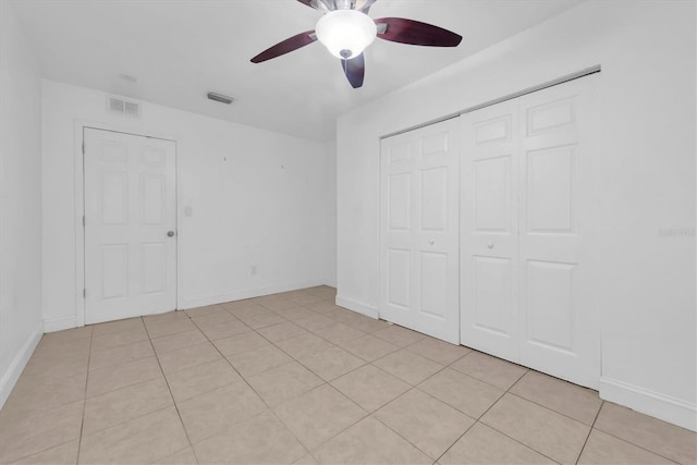 unfurnished bedroom featuring light tile patterned floors, a closet, and ceiling fan