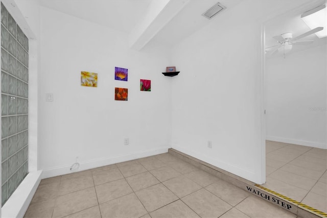 spare room with ceiling fan and light tile patterned floors