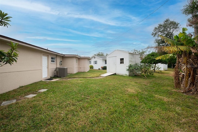 view of yard featuring a storage unit and central AC